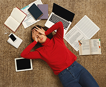 frustrated student surrounded by schoolwork